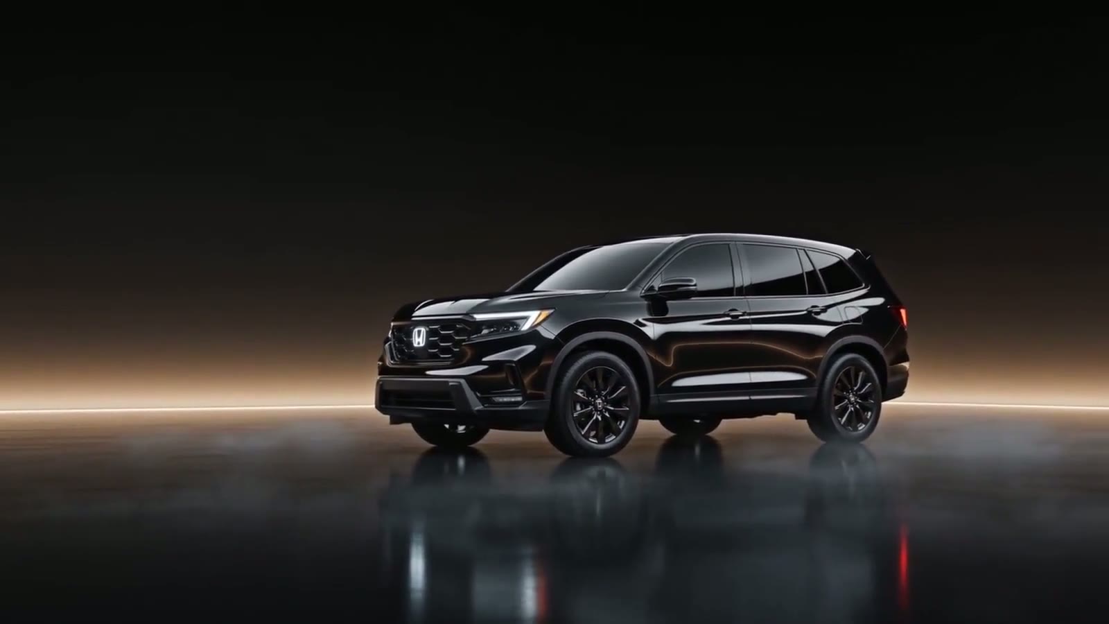 Glossy black Honda Pilot in a dark studio with warm rim lighting